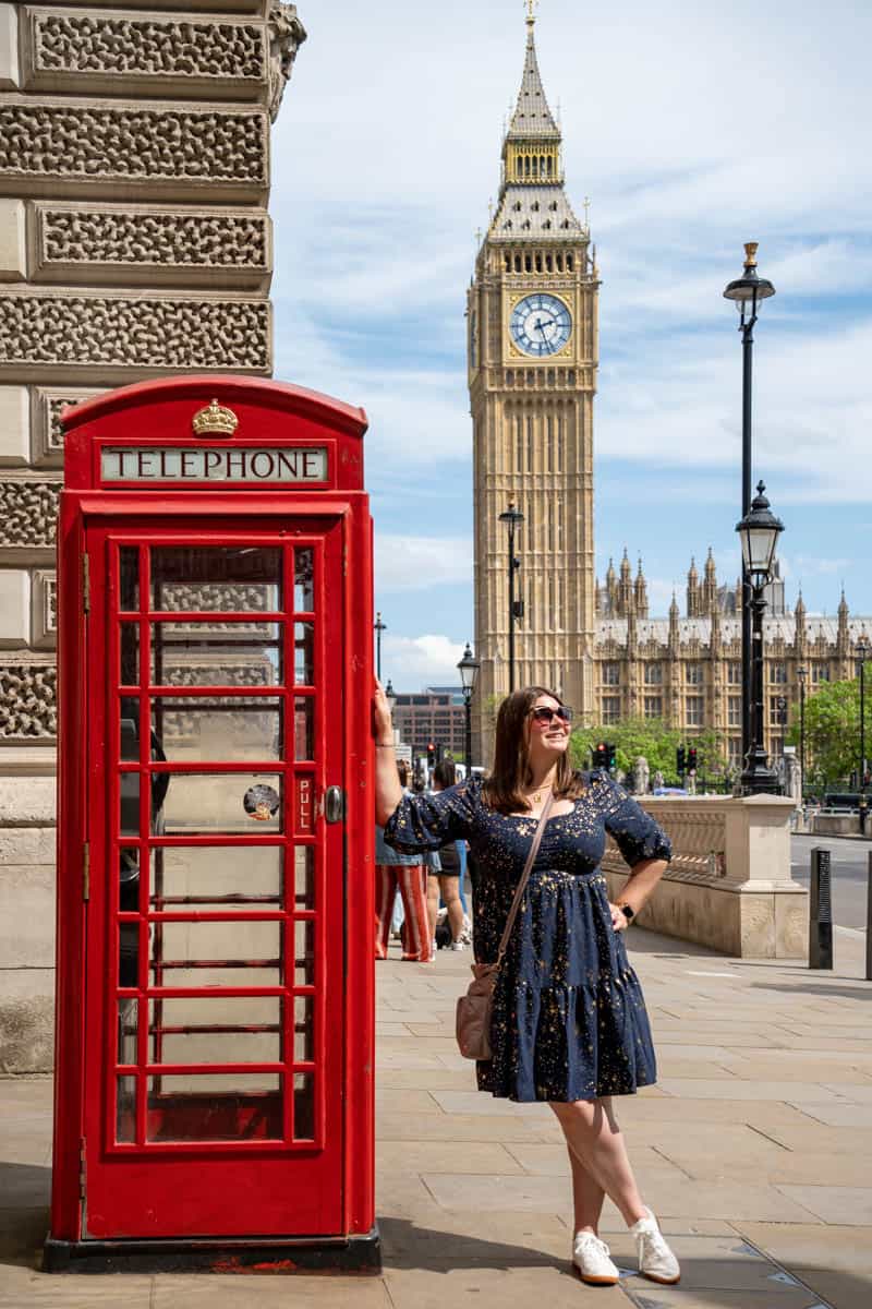 Amanda next to a red phone box with Big Ben in the background in London